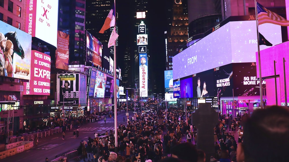 a crowd of people walking down a street next to tall buildings