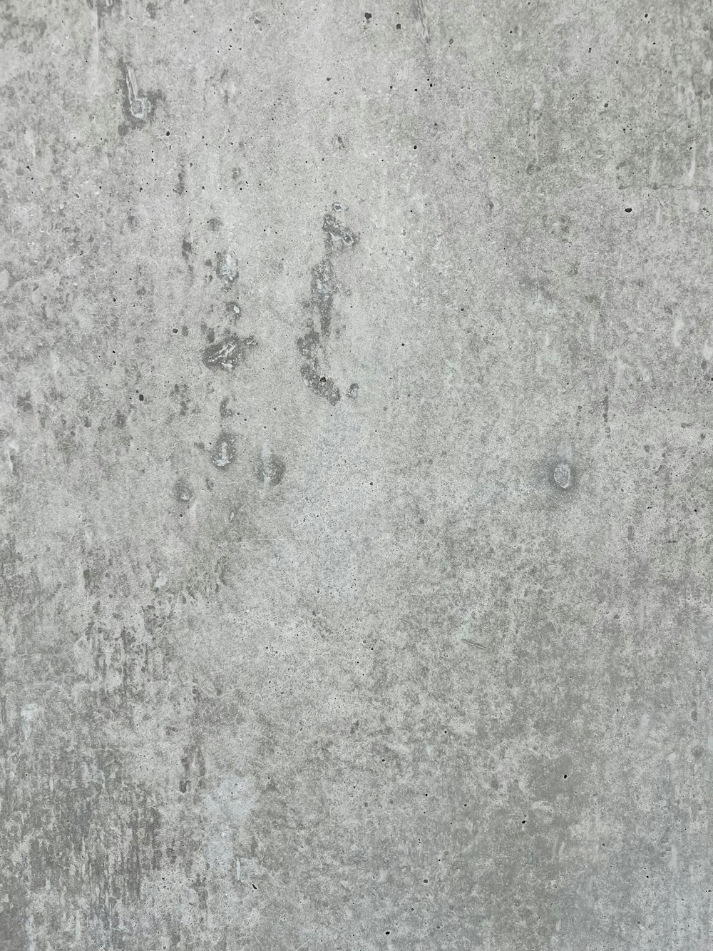 a gray concrete wall with small holes in it