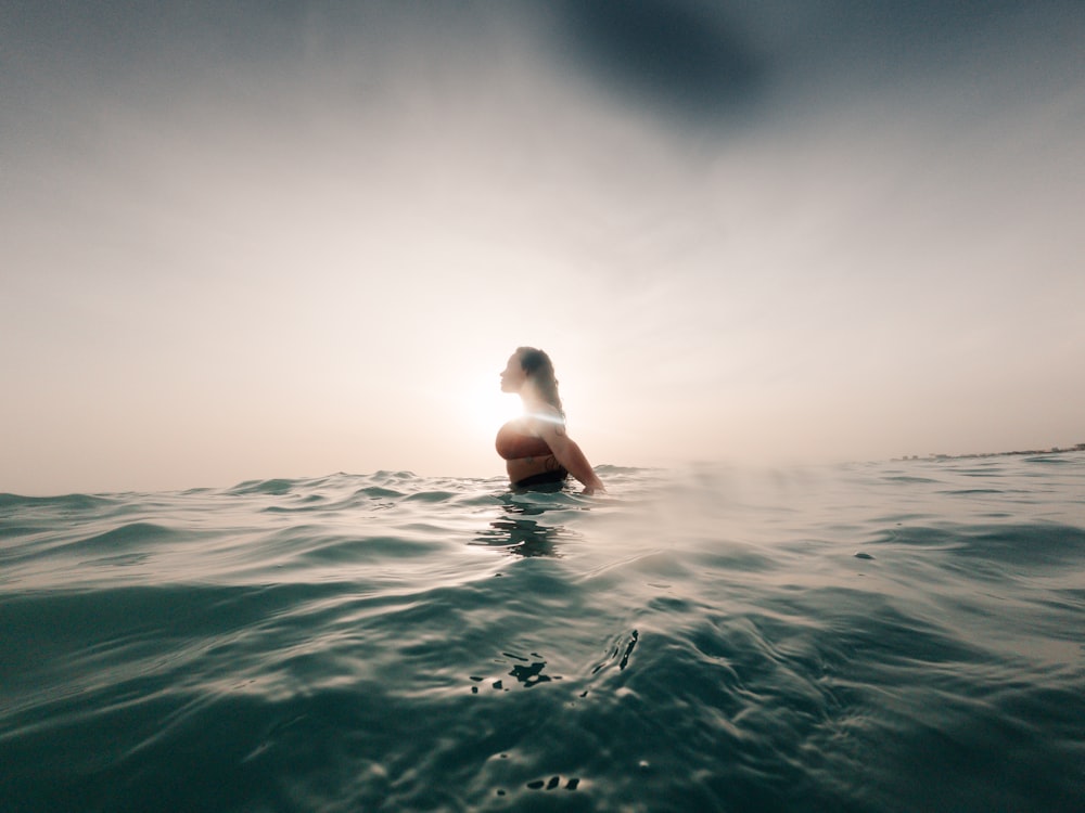 a woman sitting on a surfboard in the ocean
