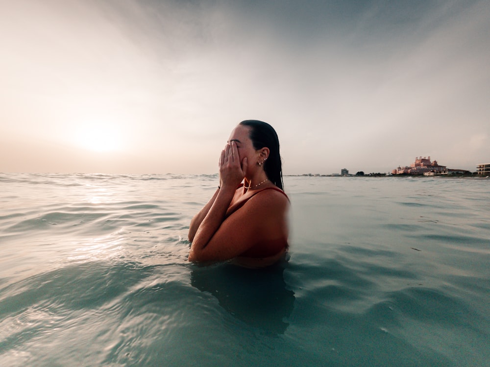 a woman sitting in the middle of the ocean