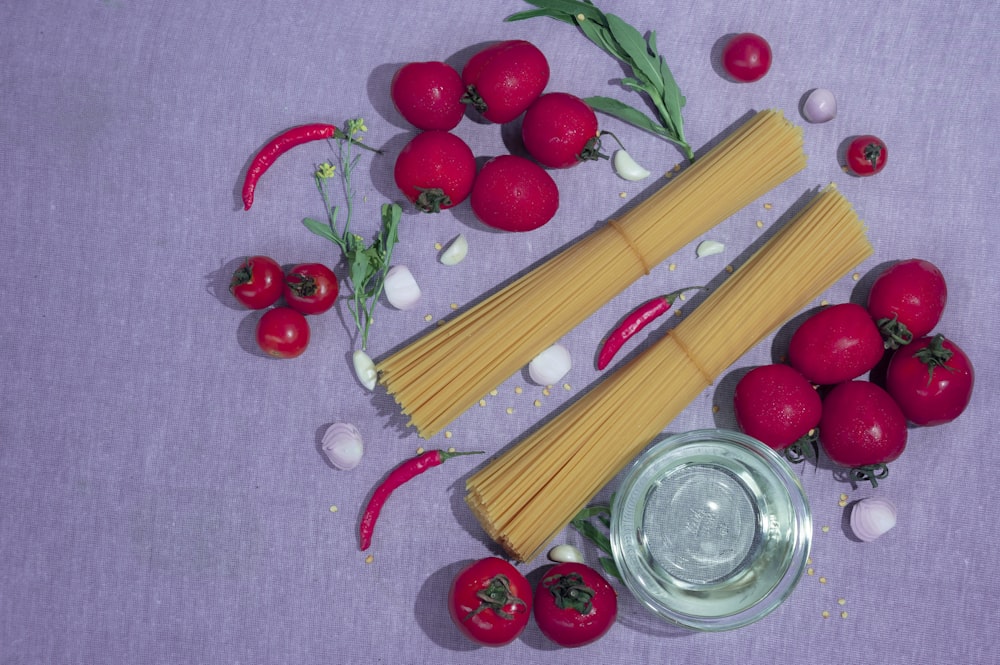 spaghetti, tomatoes, garlic and garlic on a purple surface