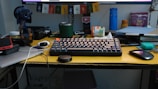 a computer keyboard sitting on top of a yellow desk