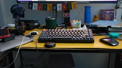a computer keyboard sitting on top of a yellow desk