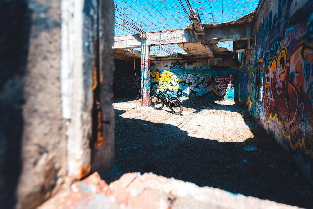 a bike parked in an alley with graffiti on the walls