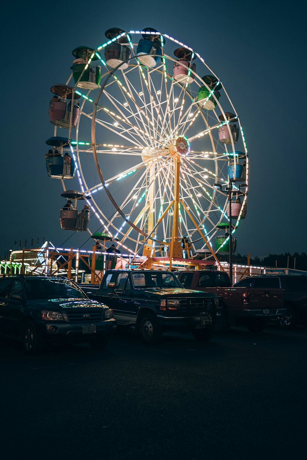 a ferris wheel in a parking lot at night