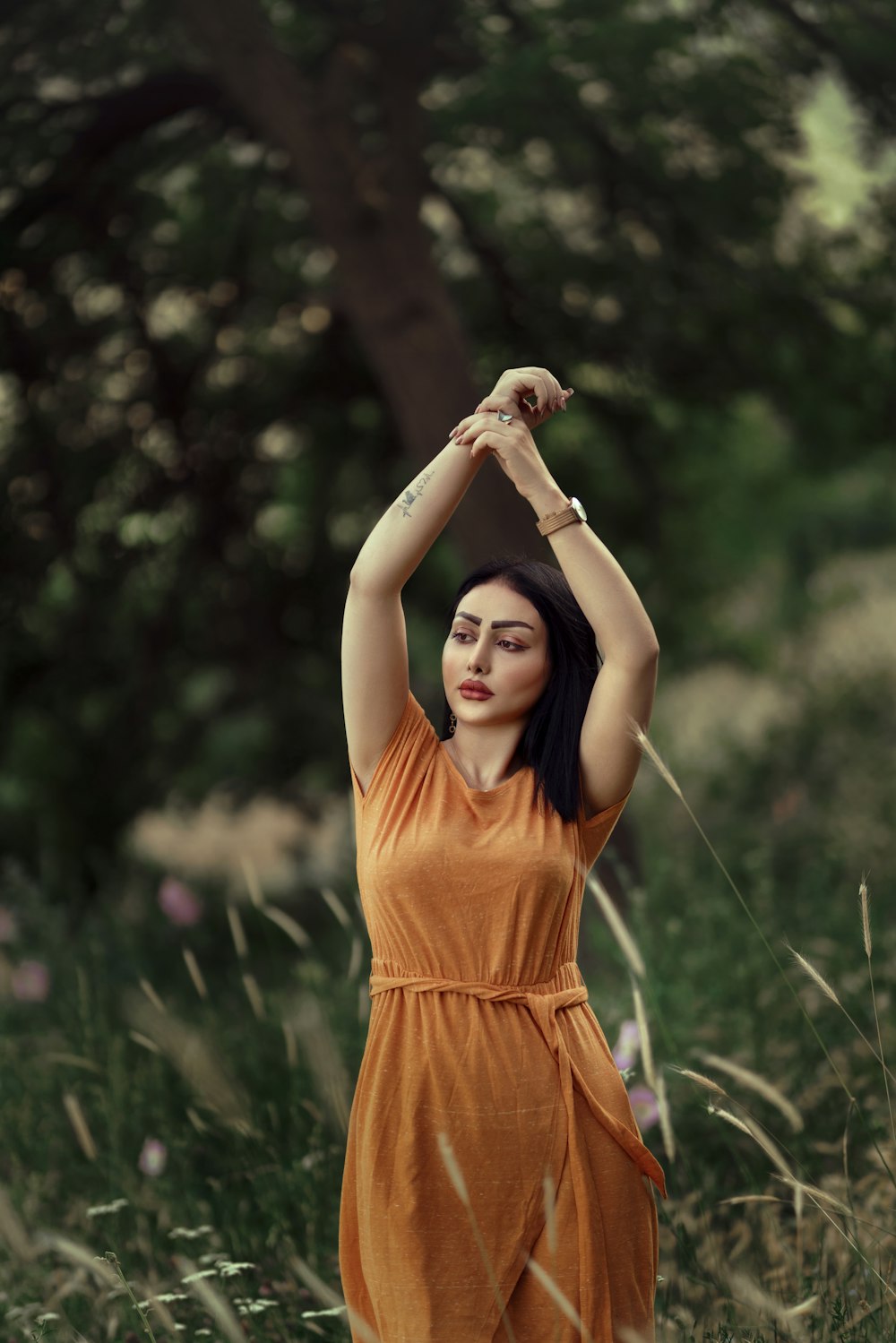 a woman in an orange dress standing in a field