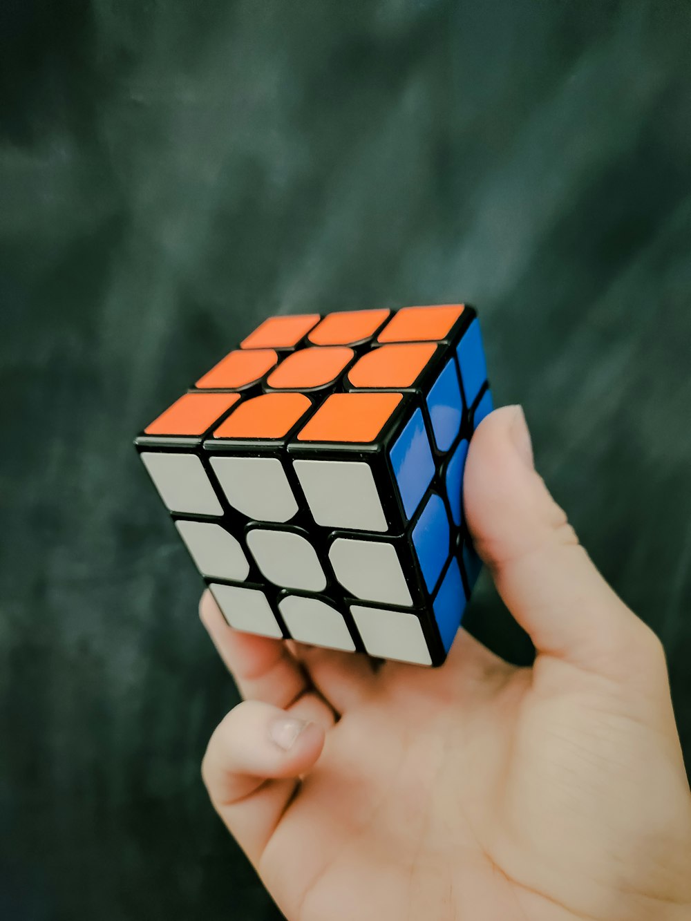 a person holding a rubik cube in their hand