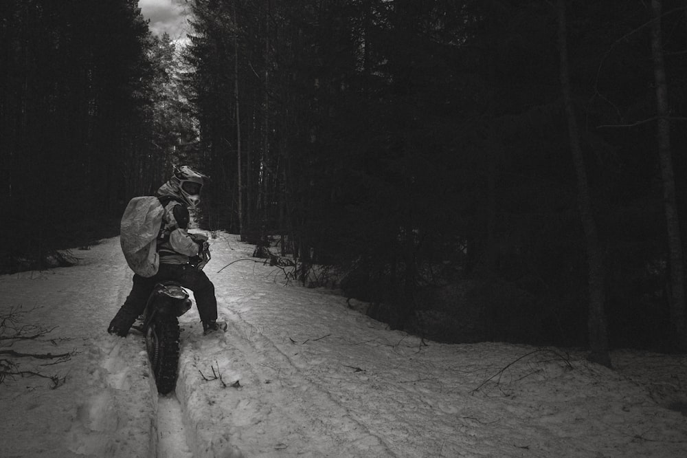 a man riding a snowboard down a snow covered road