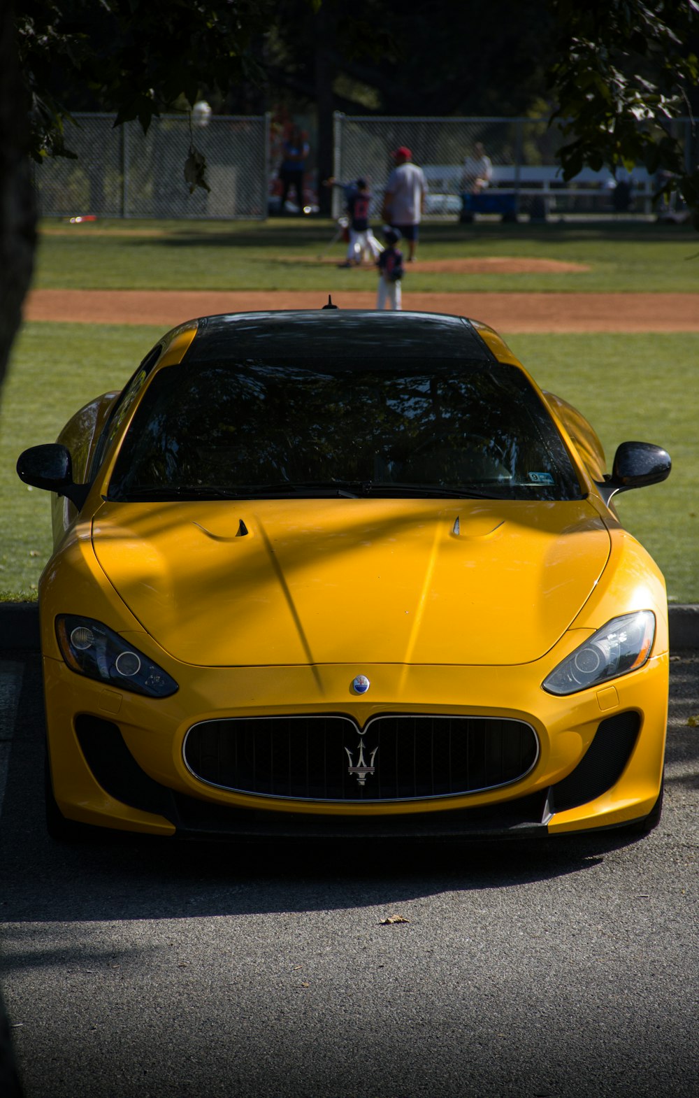 a yellow sports car parked on the side of the road