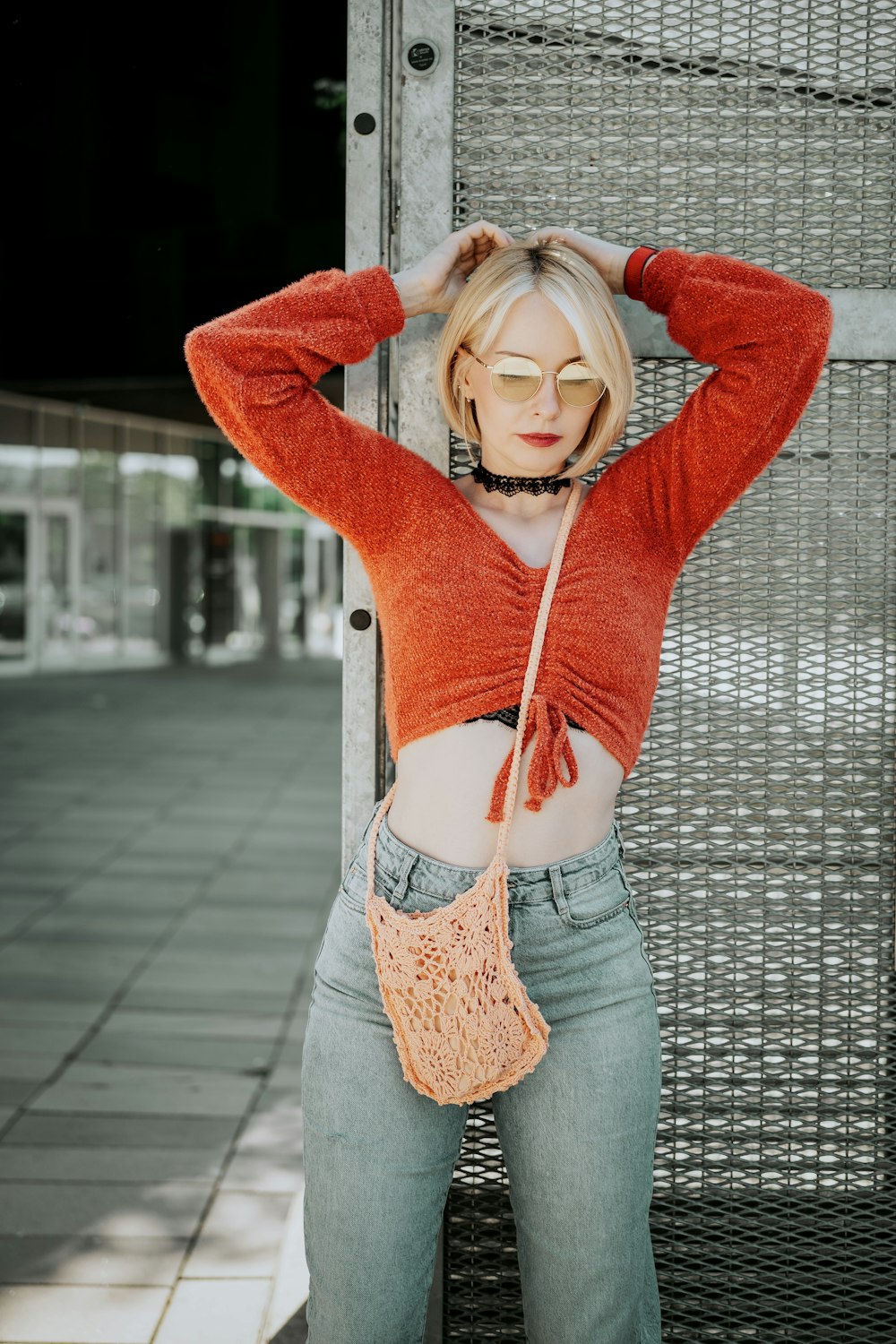 a woman in a crop top is holding a purse