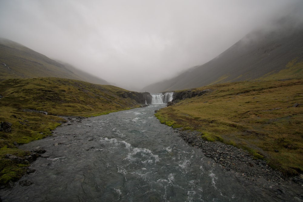 a river running through a lush green valley