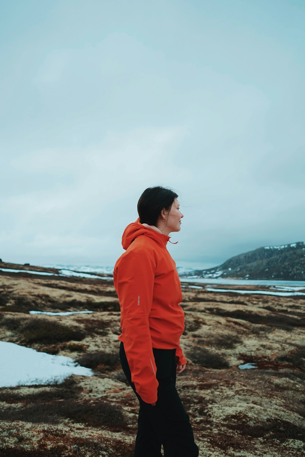 a man in an orange hoodie standing in a field