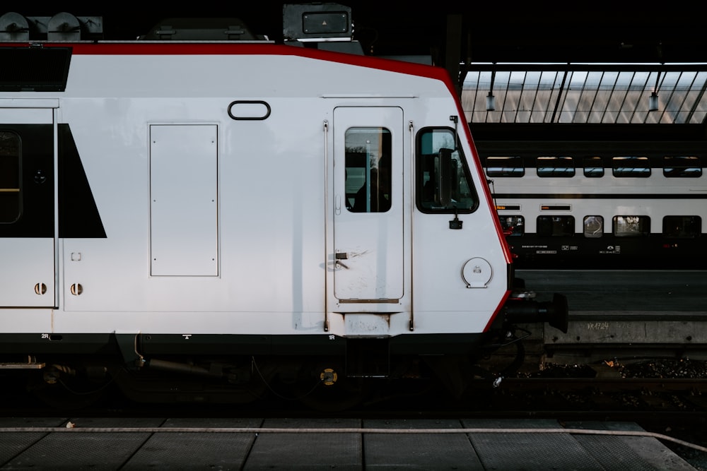 a white and red train is parked at a train station