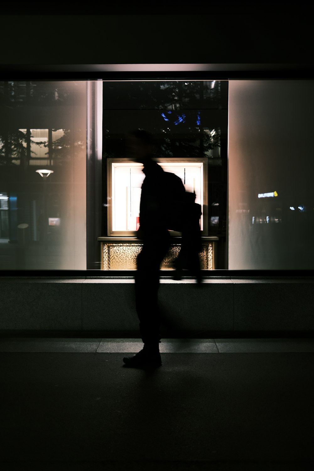 a silhouette of a person standing in front of a window