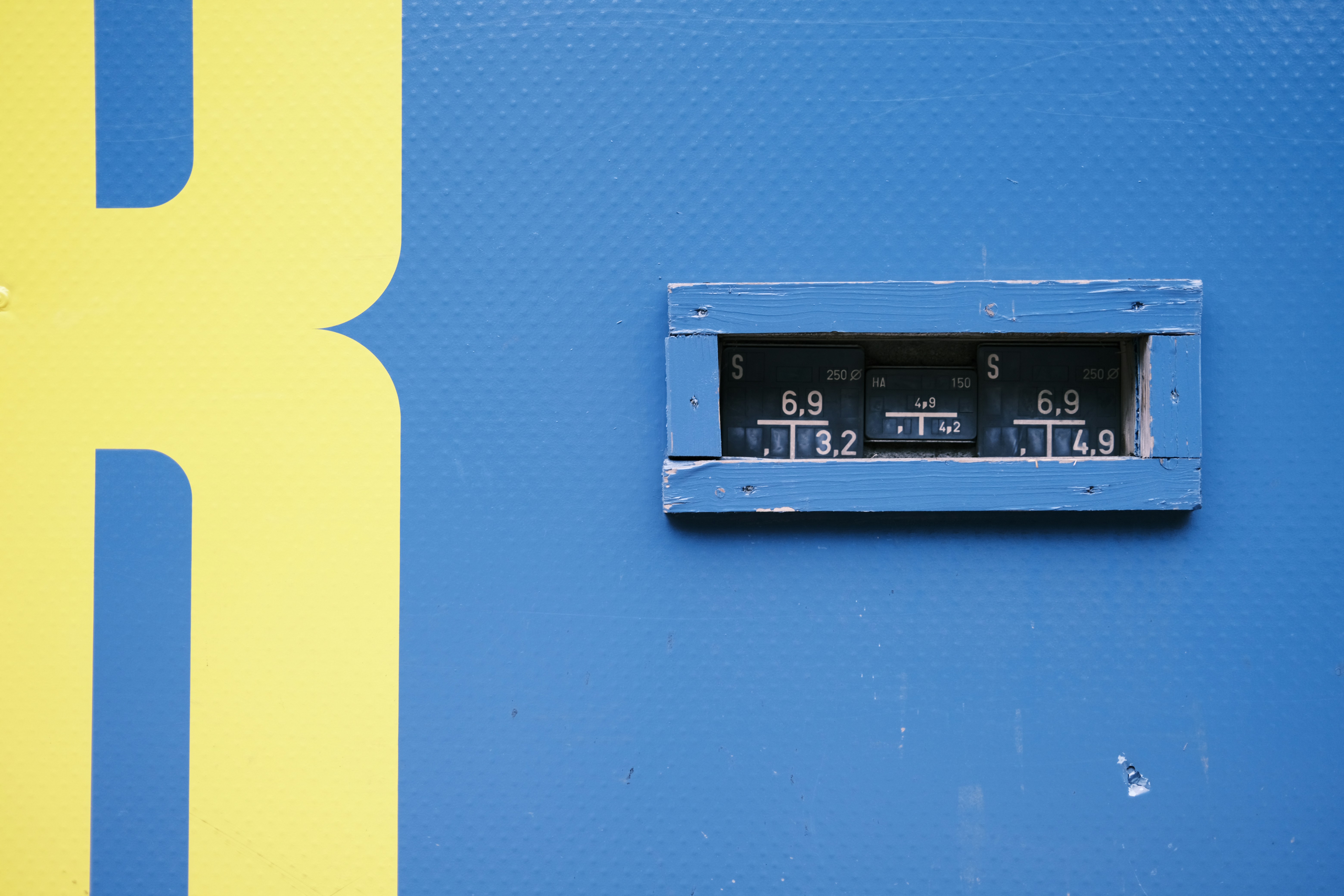 a blue and yellow wall with a clock on it