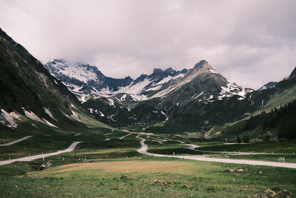 a scenic view of a mountain range with a winding road