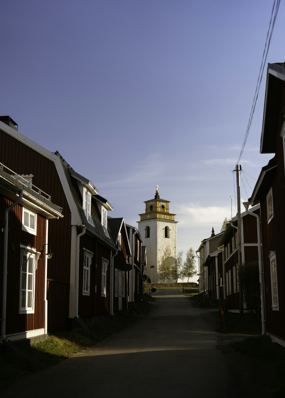 a narrow street with a church in the background