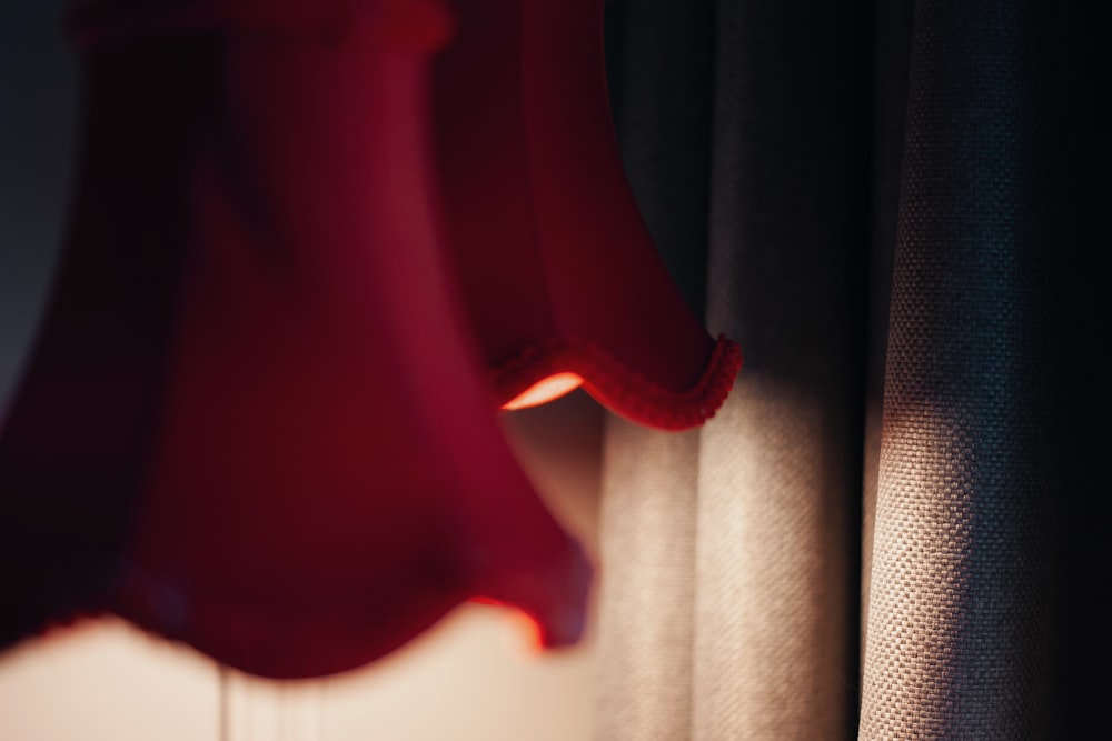 a red dress hanging on a curtain in a room
