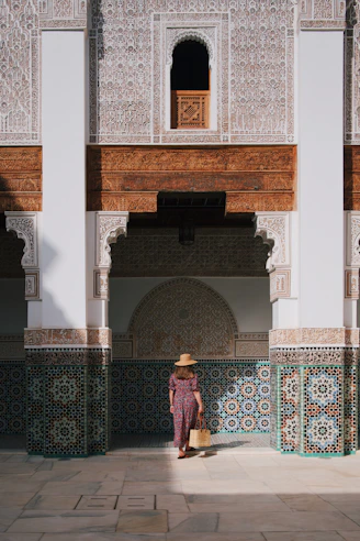 a woman in a hat standing in front of a building