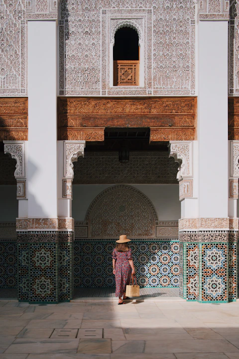 a woman in a hat standing in front of a building