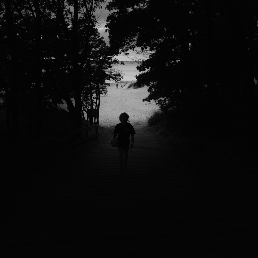 a person walking down a path in the dark