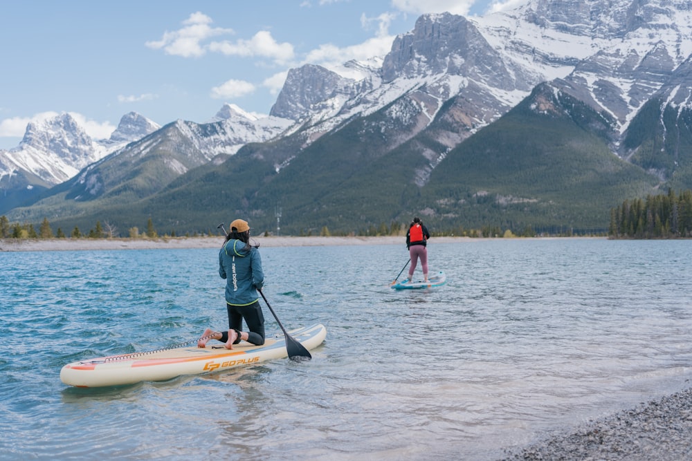 a couple of people standing on top of a paddle board