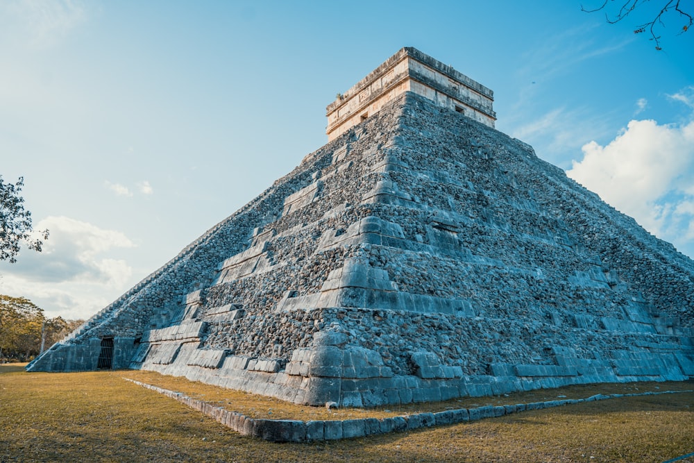 a very tall pyramid sitting in the middle of a field