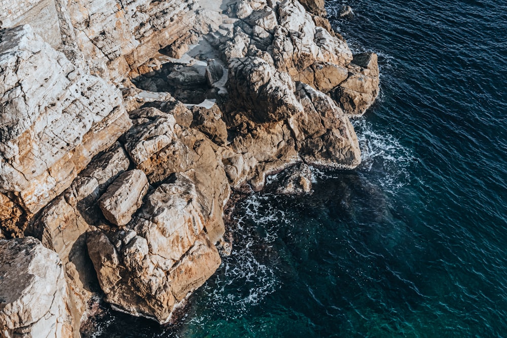 uma vista aérea de uma costa rochosa com água azul clara