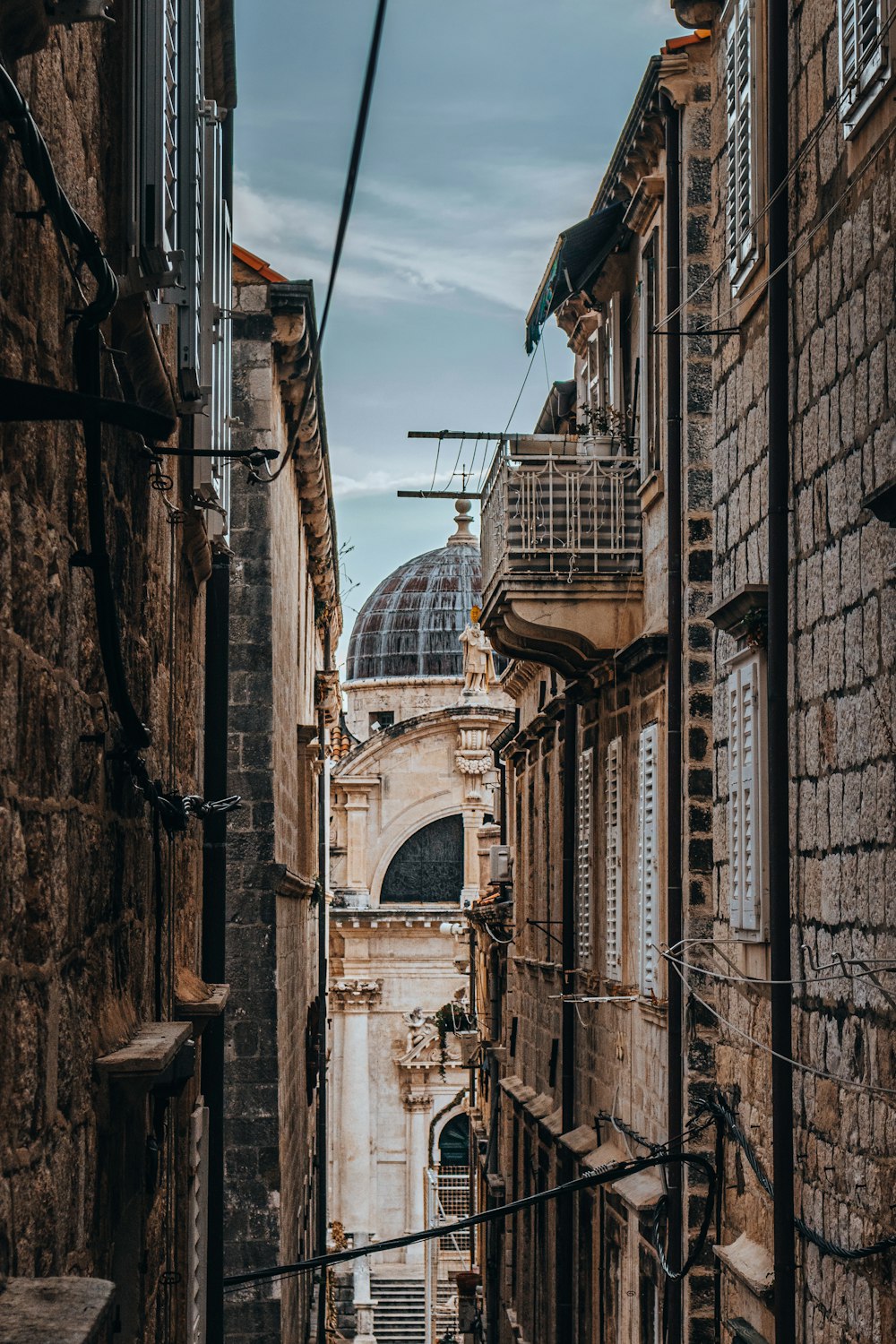 a narrow alley way with a clock tower in the background