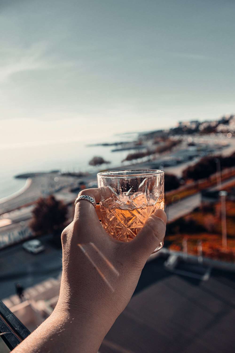 a person holding a glass with a beverage in it