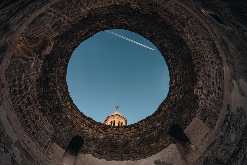 a view of a church through a hole in a wall