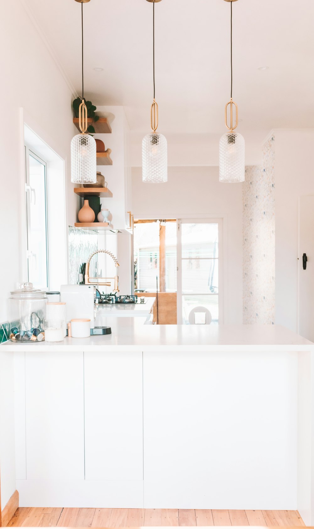 a kitchen with a white counter top and wooden floors