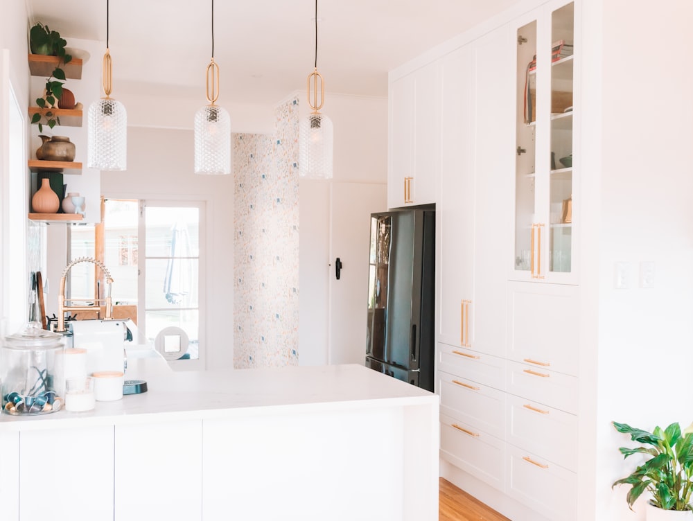 a kitchen with white cabinets and a black refrigerator