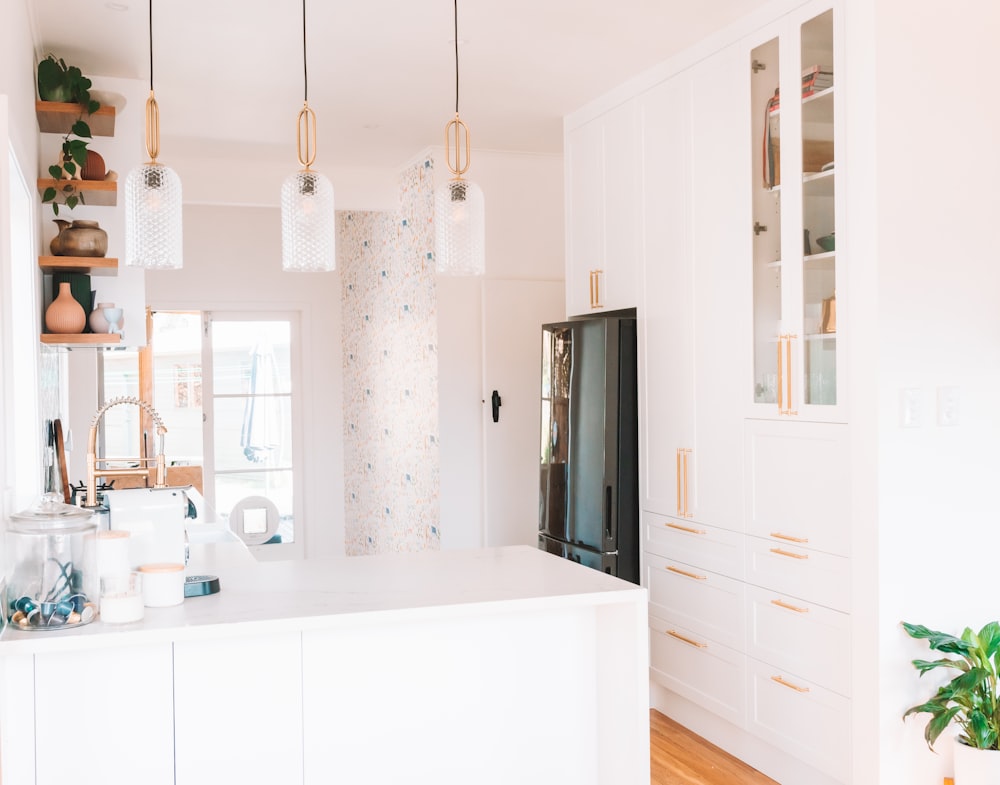 a kitchen with white cabinets and a black refrigerator