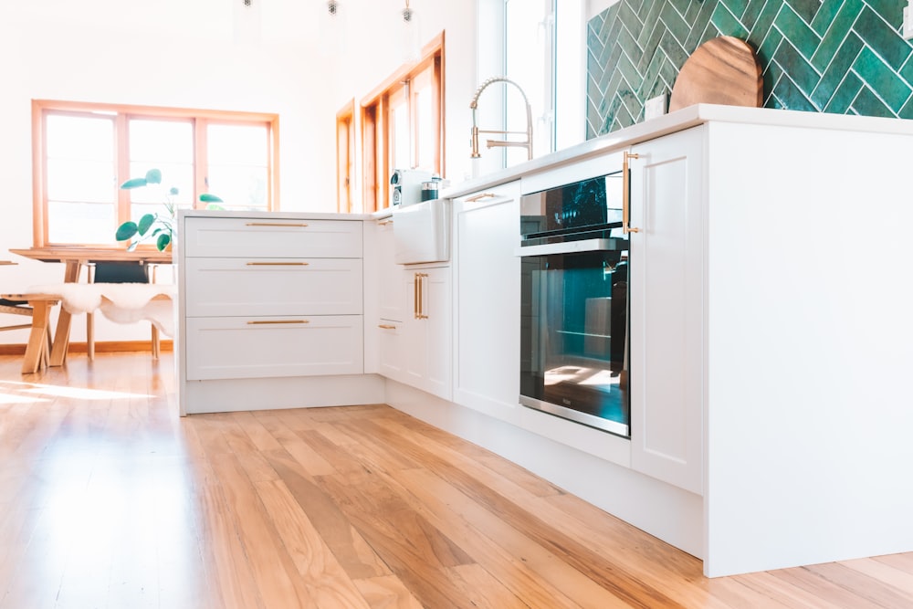 a kitchen with white cabinets and a wood floor