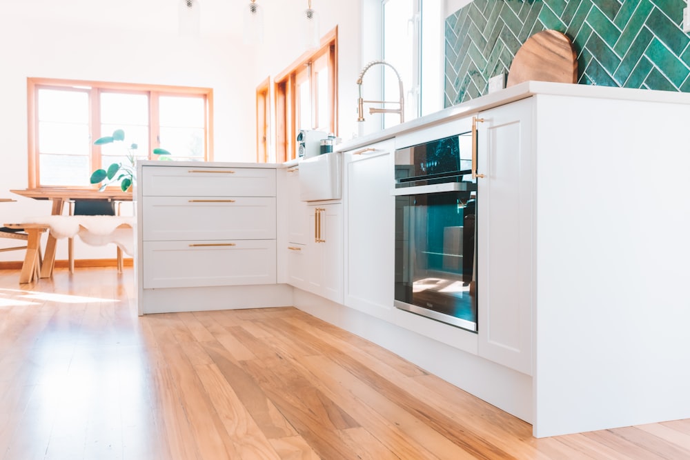 a kitchen with white cabinets and a wood floor