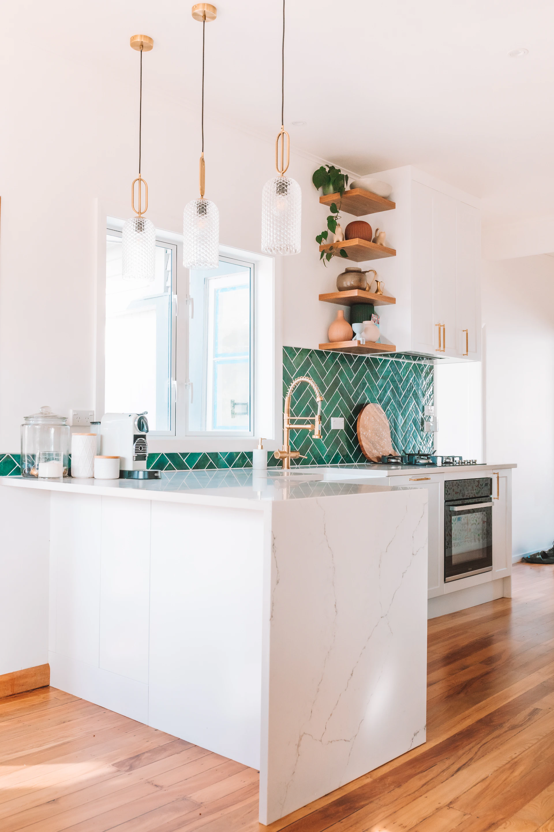 A bright kitchen featuring a marble backsplash and custom-built wooden cabinets in a cozy home setting.