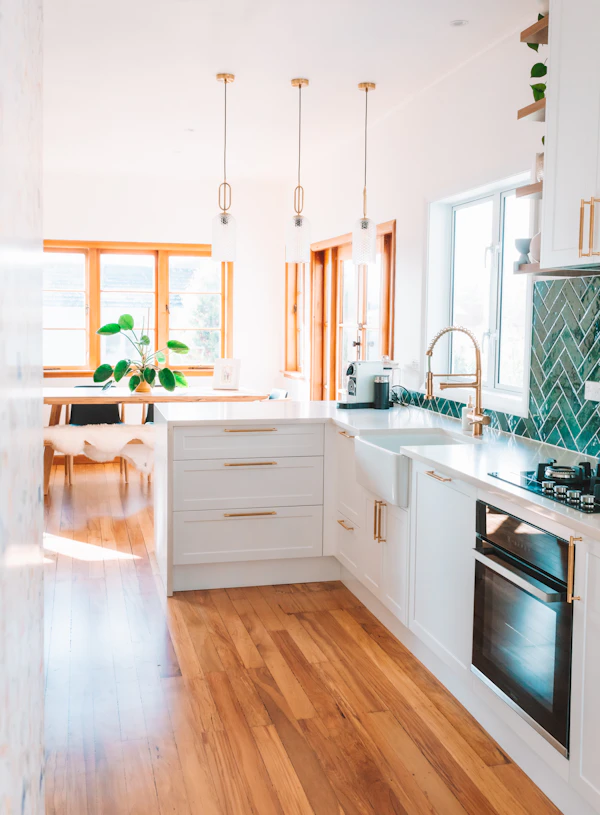Kitchen Plumbing Planning: a kitchen with white cabinets and wood floors