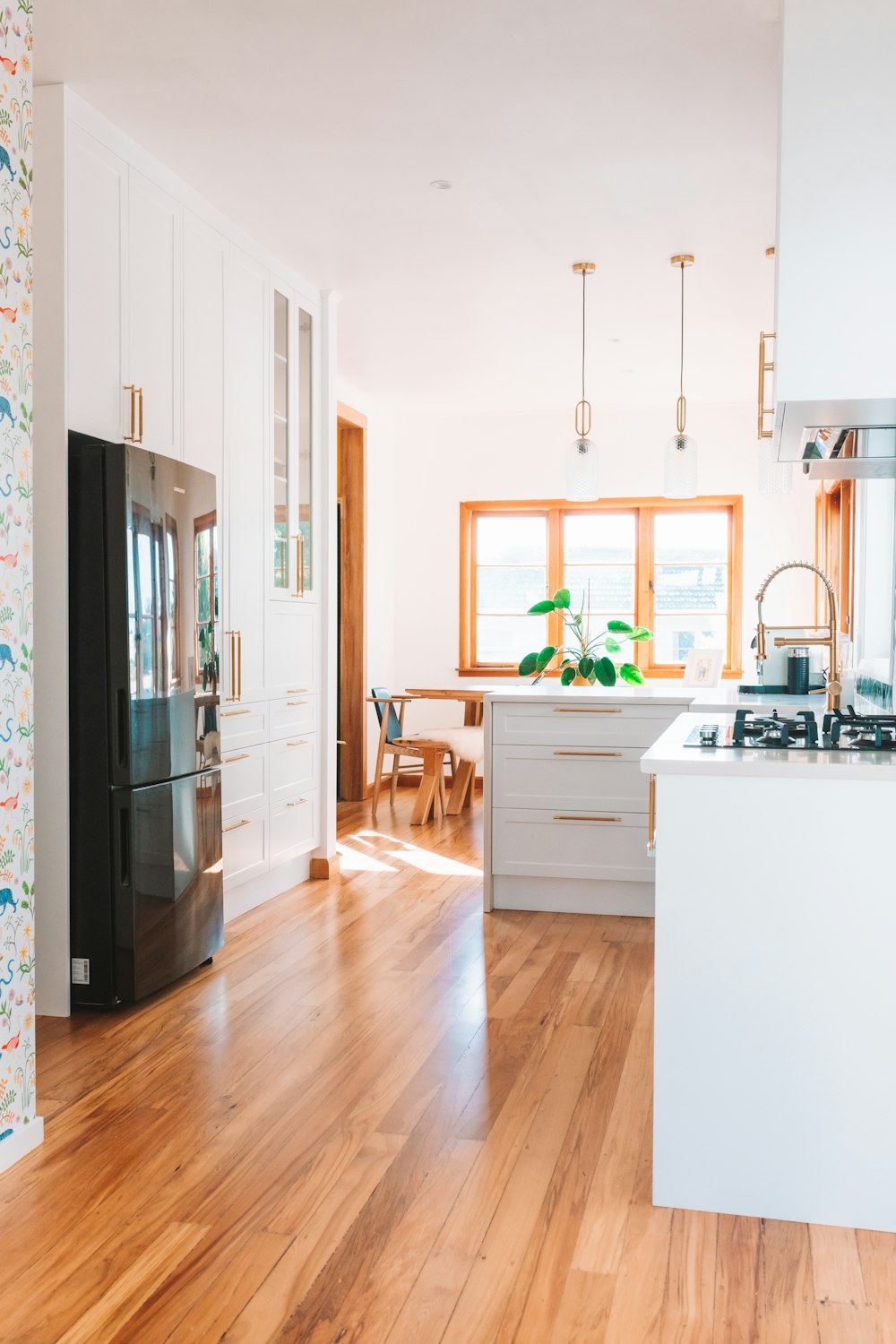 a kitchen with wood floors and white cabinets