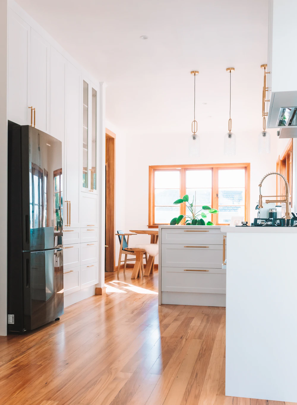 A black refrigerator freezer in a modern kitchen next to a window