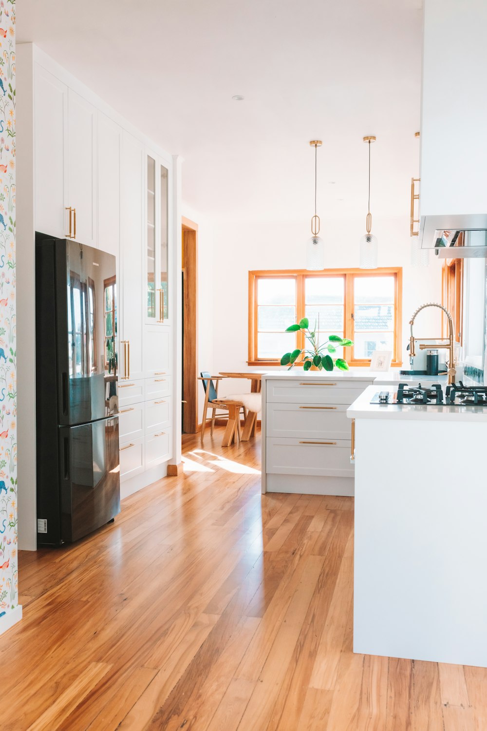 a kitchen with wood floors and white cabinets