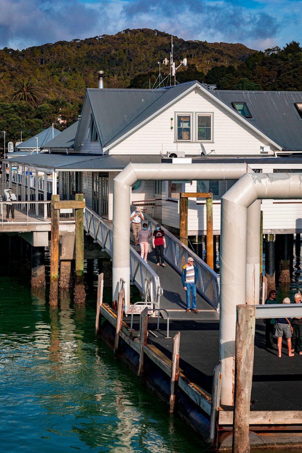 a group of people walking across a bridge over water