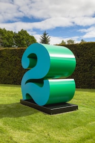 a large blue number sitting on top of a lush green field