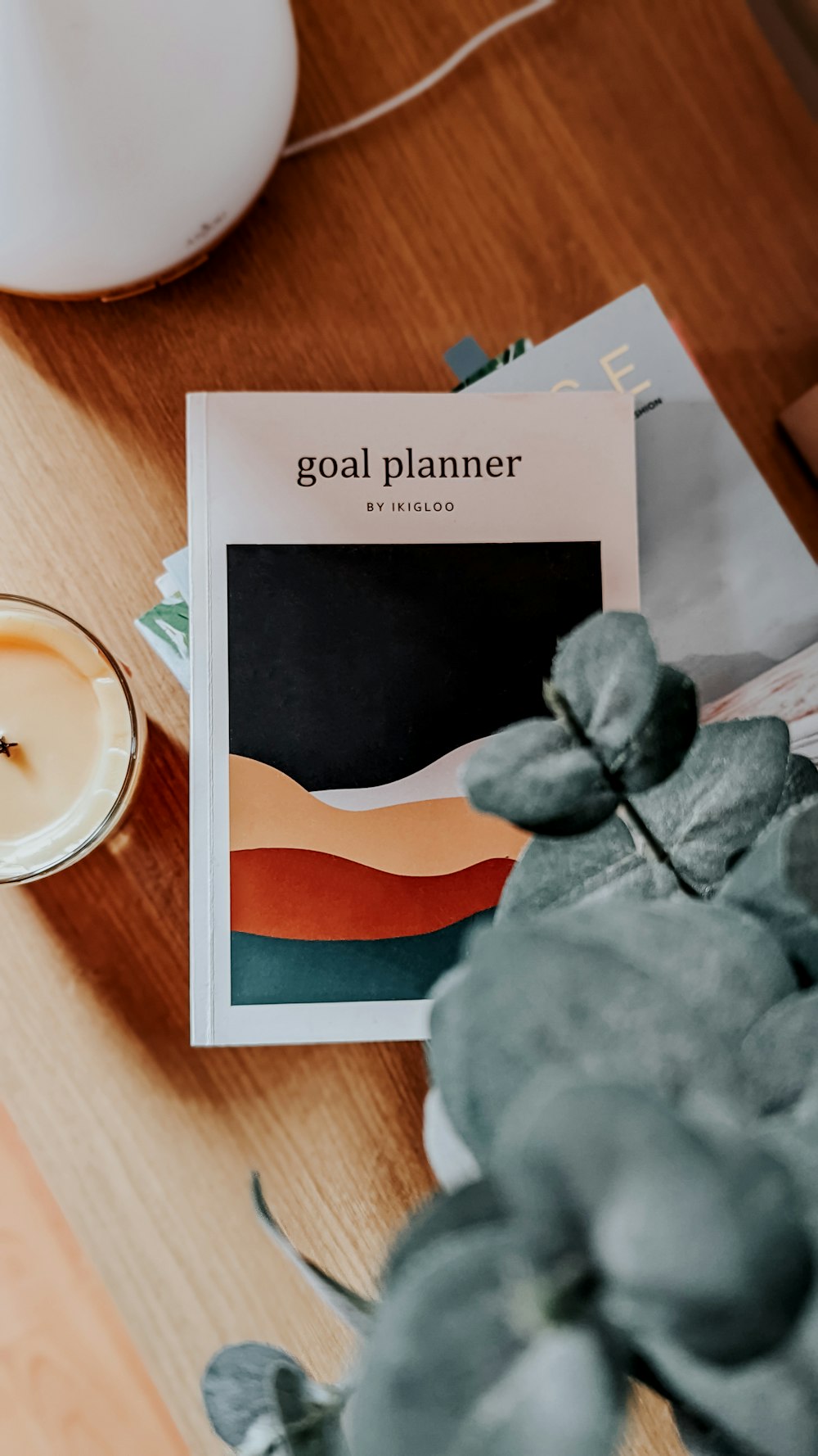 a table with a plant and a candle on it