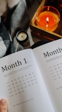 a person holding a book open to a calendar