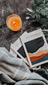 a couple of pamphlets sitting on top of a table next to a candle