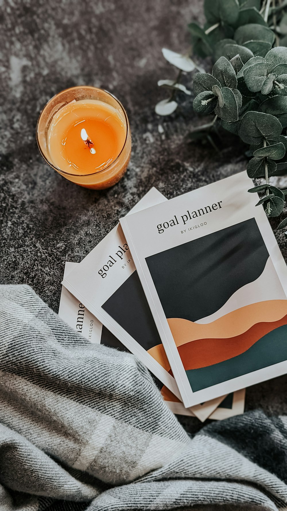 a couple of pamphlets sitting on top of a table next to a candle