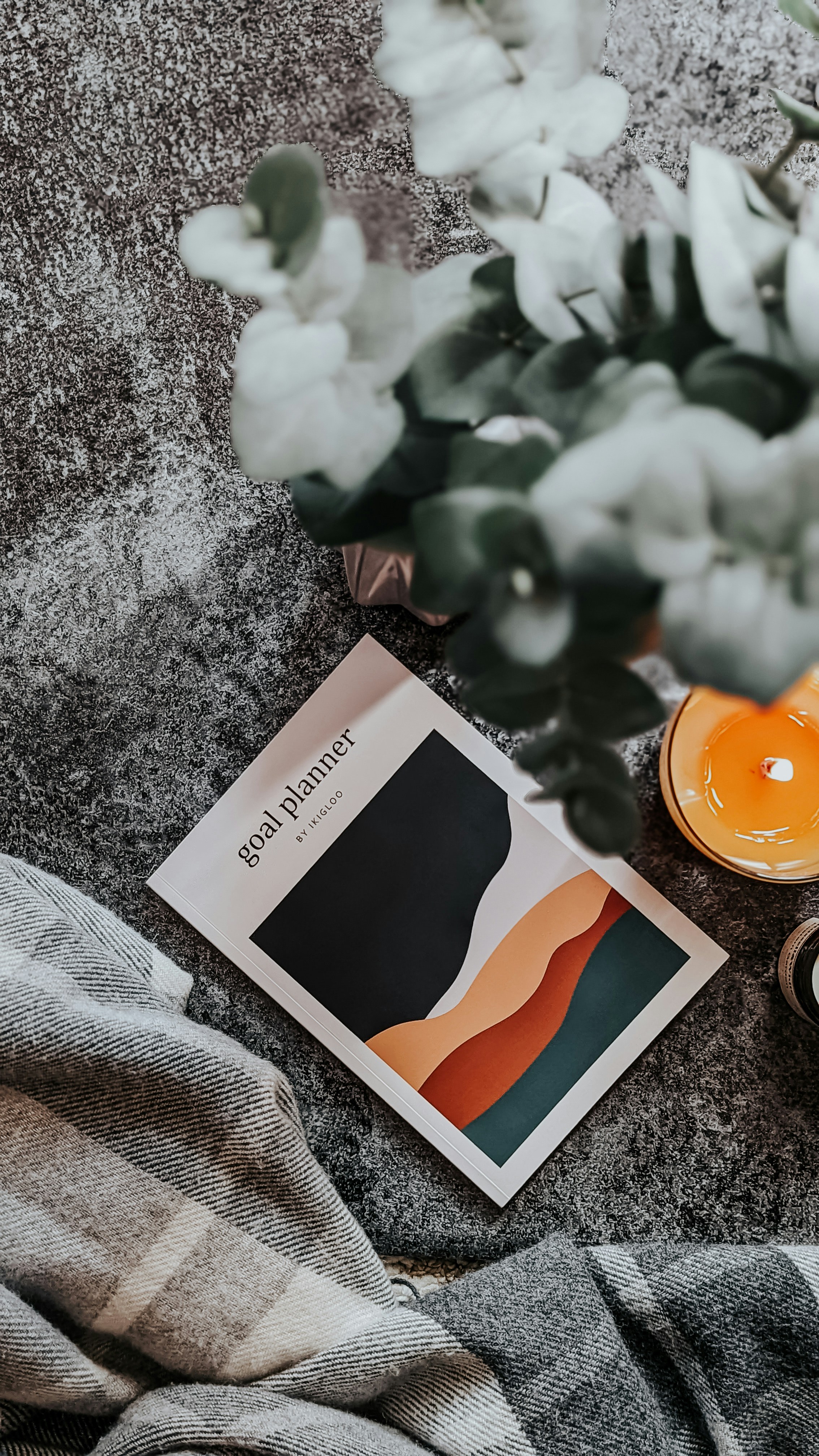 a candle and a book on a blanket