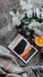 a candle and a book on a blanket