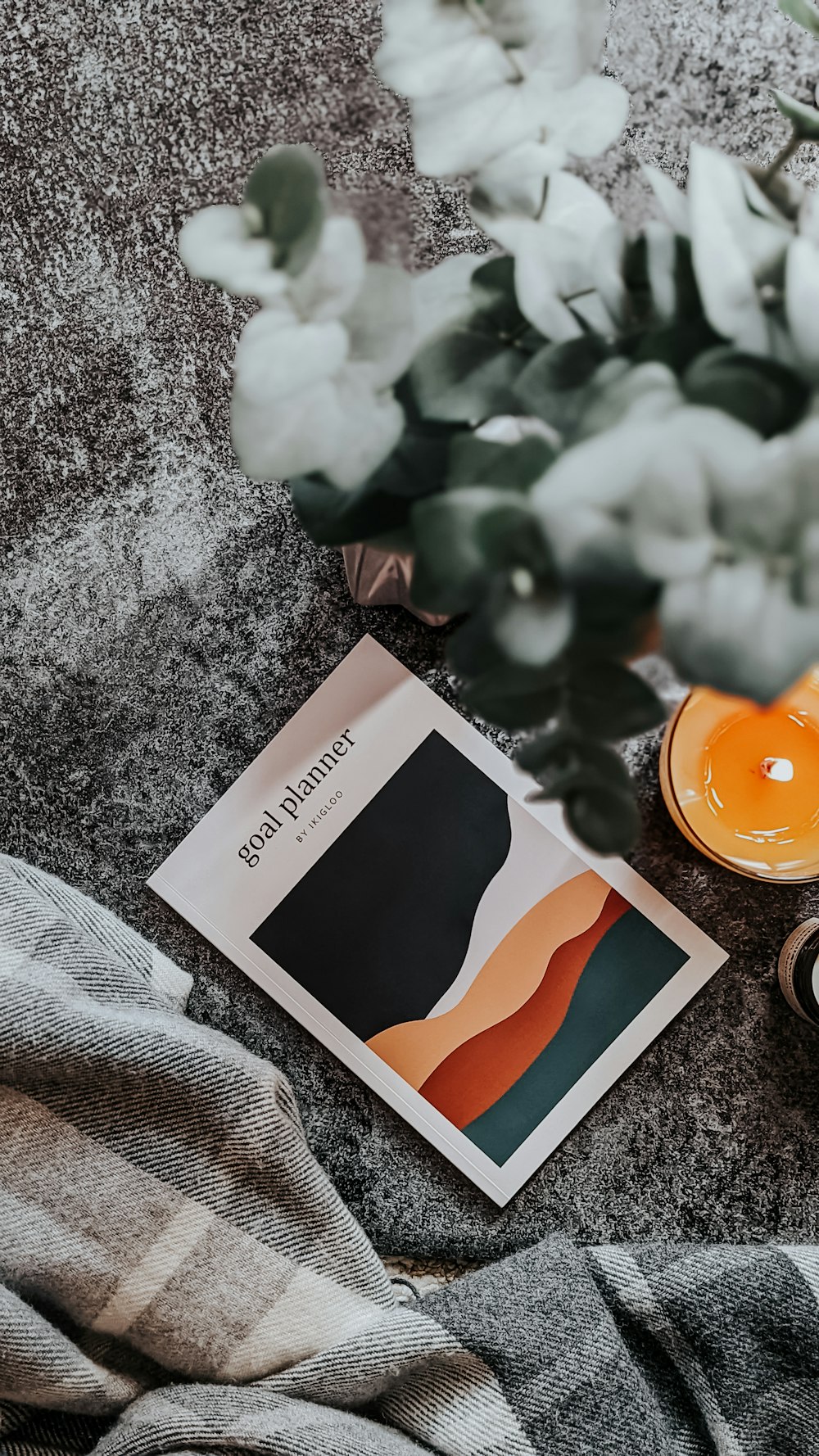 a candle and a book on a blanket
